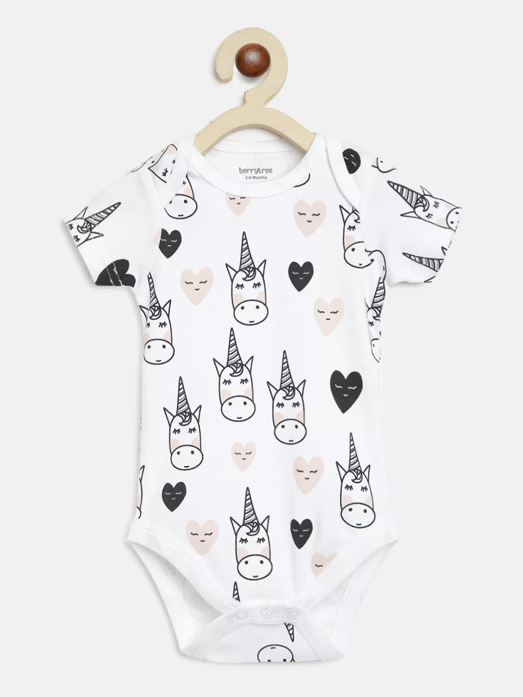 Baby onesie with unicorn and heart pattern on a hanger against a white background