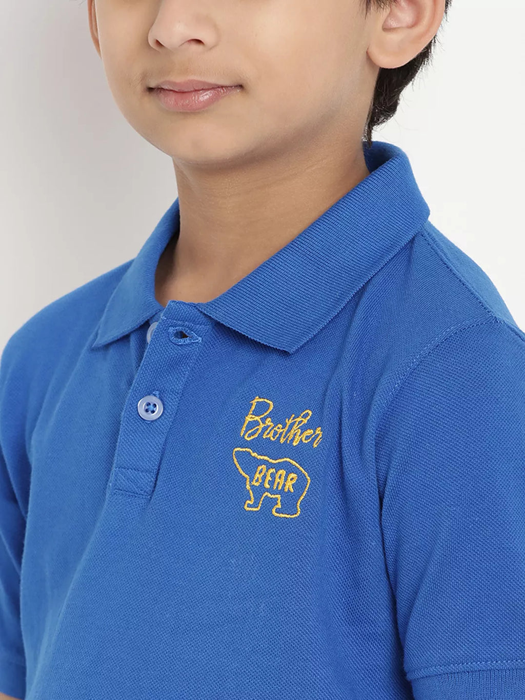Blue polo shirt with 'Brother Bear' embroidery on a plain background