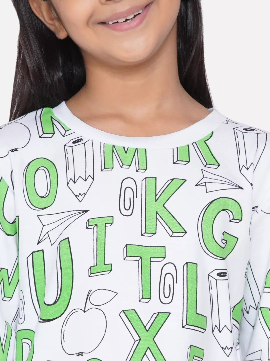 Child wearing a white shirt with green letters and symbols