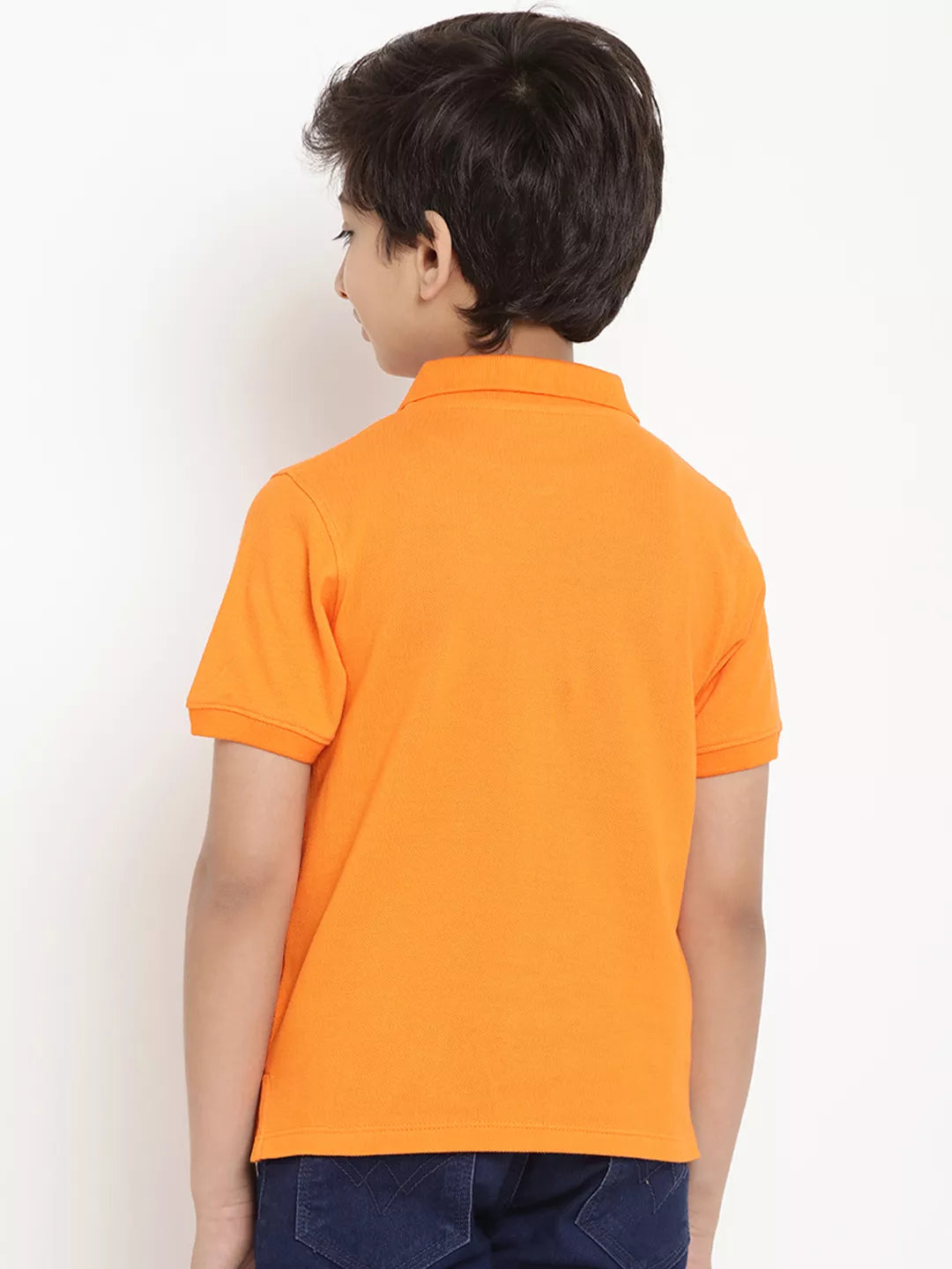 Child wearing an orange polo shirt against a white background