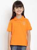 Young girl wearing an orange polo shirt with a logo on a white background