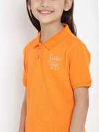 Child wearing an orange polo shirt with a logo on a white background