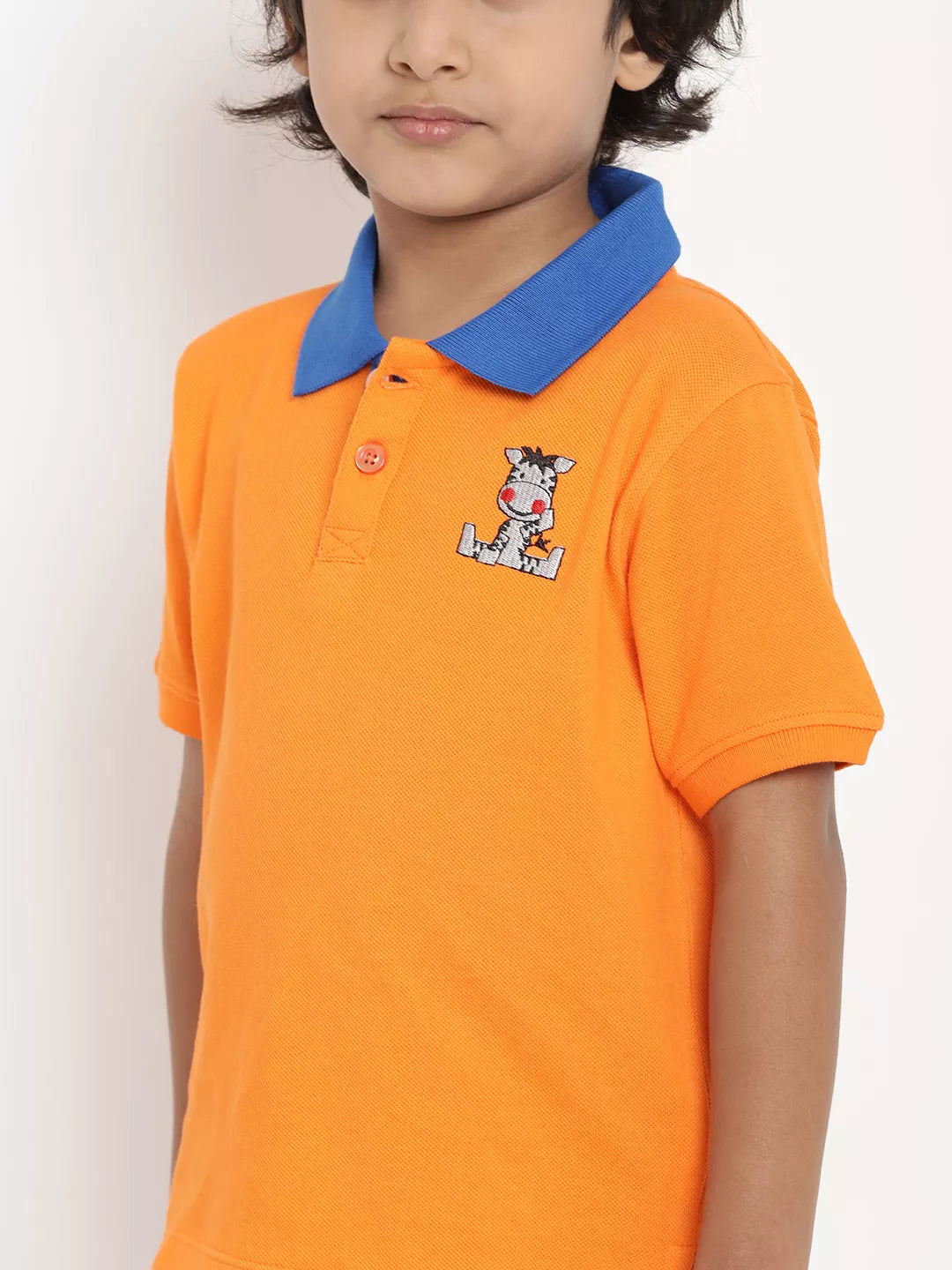 Child wearing an orange polo shirt with a blue collar and cartoon character on a white background