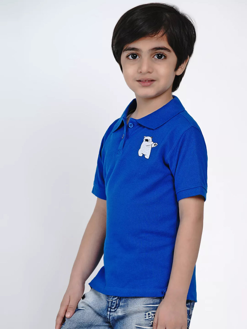 Child wearing a blue polo shirt with a white logo on a white background