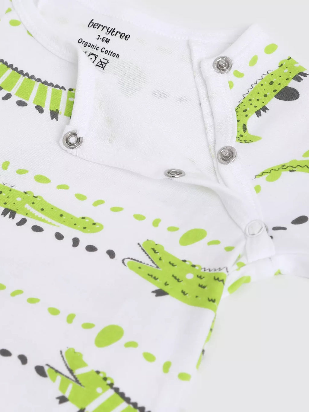 Baby romper with green and black crocodile pattern on a white background