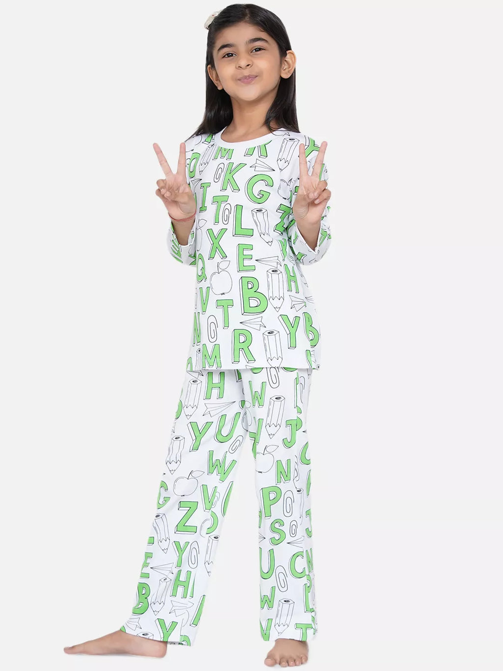 Child wearing a pajama set with alphabet pattern on a white background