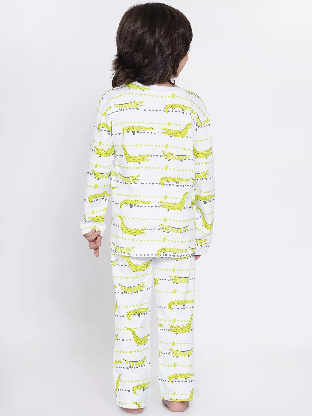 Person wearing a pajama set with green dinosaur pattern on a white background