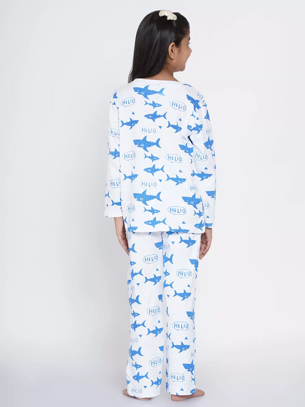 Person wearing shark-themed pajamas with a white background