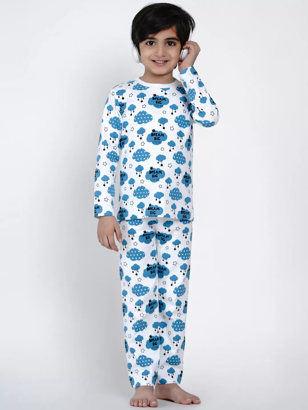Child wearing a white onesie with blue cloud pattern on a plain background