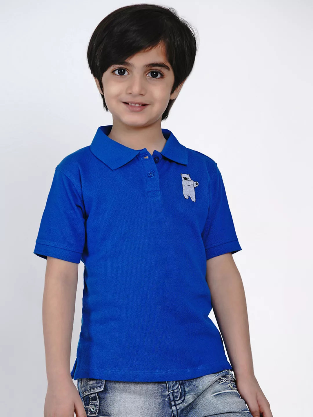 Child wearing a blue polo shirt with a white logo on a white background