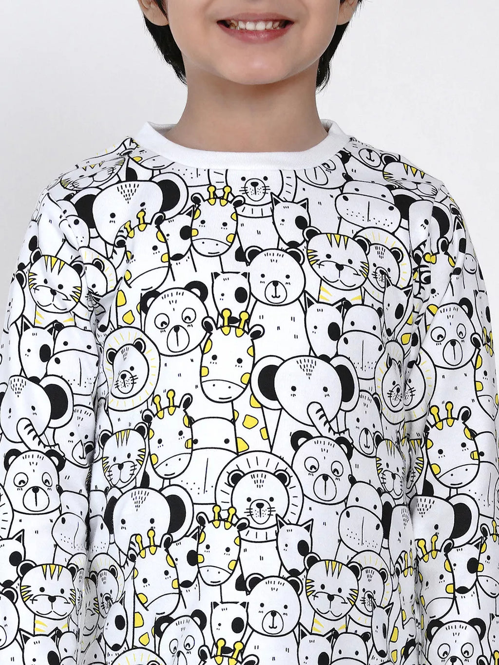 Child wearing a shirt with a black and white pattern of cartoon animals on a light gray background