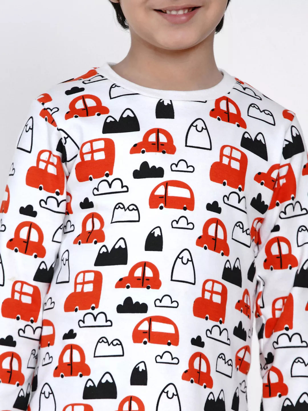 Child wearing a shirt with red car pattern on a white background