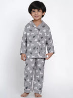 Child wearing gray pajamas with animal prints on a white background