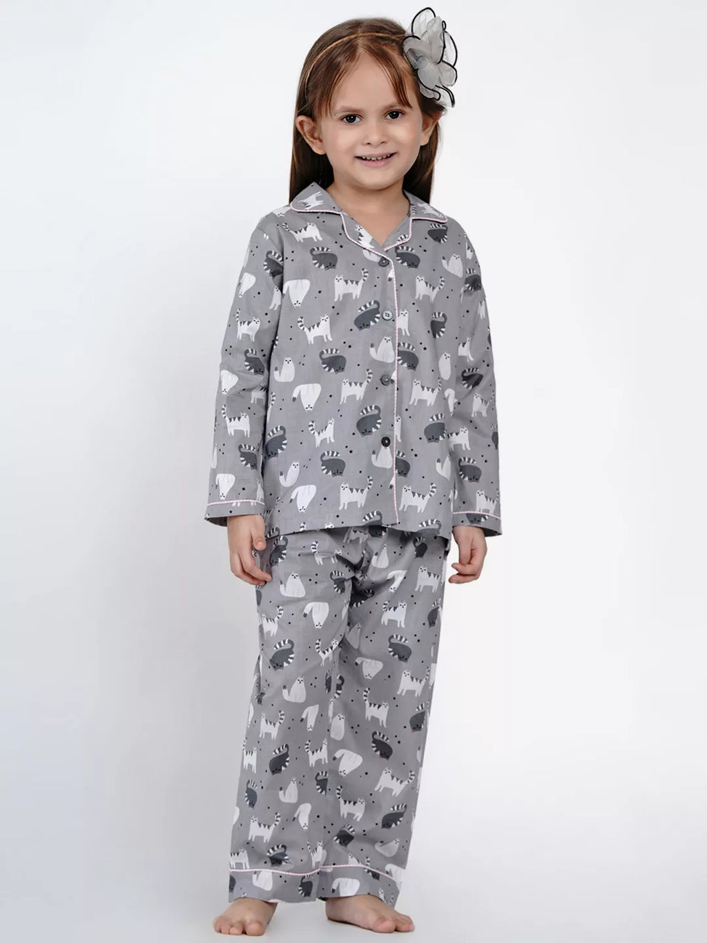 Child wearing gray pajamas with animal pattern on a white background