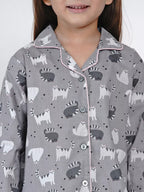 Child wearing a gray pajama set with animal pattern on a white background