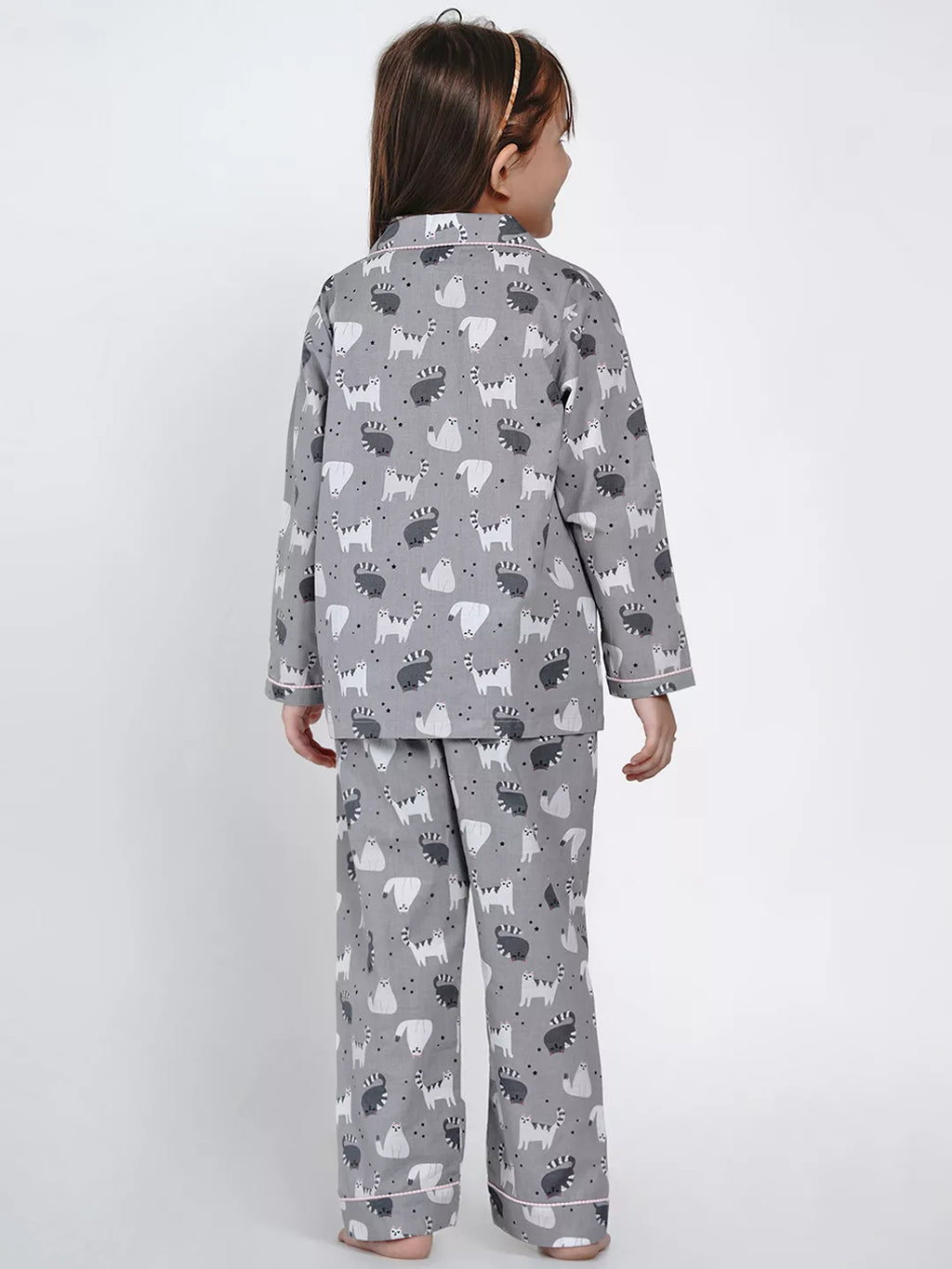 Child wearing gray pajamas with animal pattern on a white background