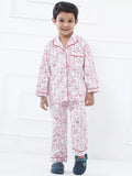 Child wearing a red and white floral pajama set on a white background