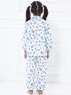 Child wearing a pajama set with a pattern of cartoon characters on a white background