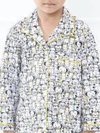 Child wearing a pajama set with a black and white pattern on a white background
