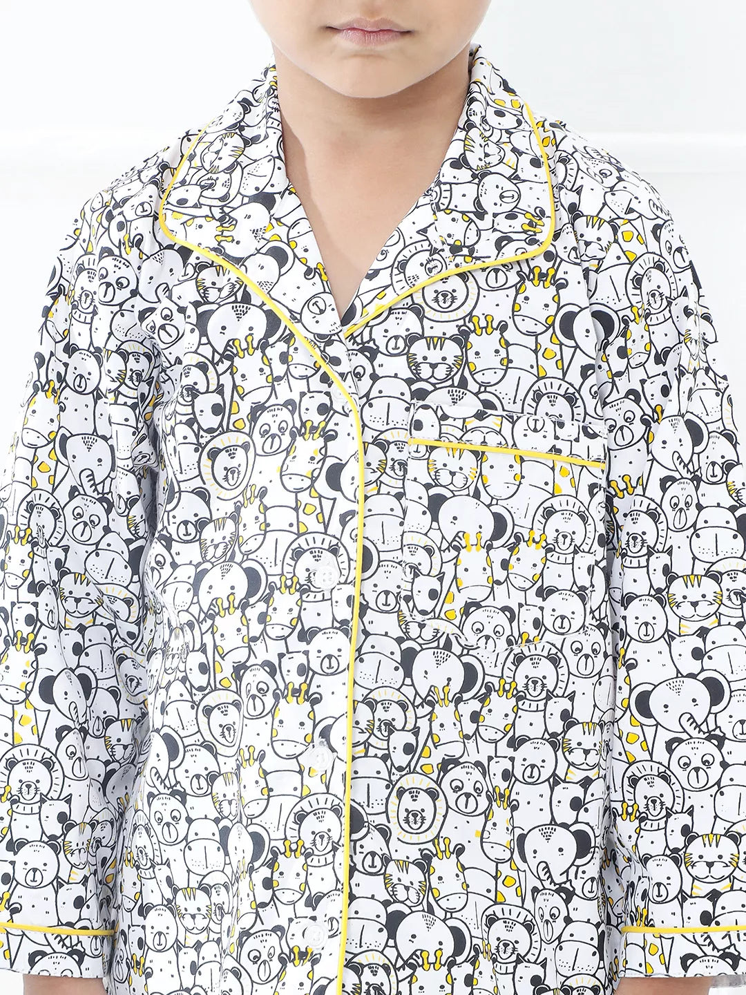 Child wearing a pajama set with a black and white pattern on a white background