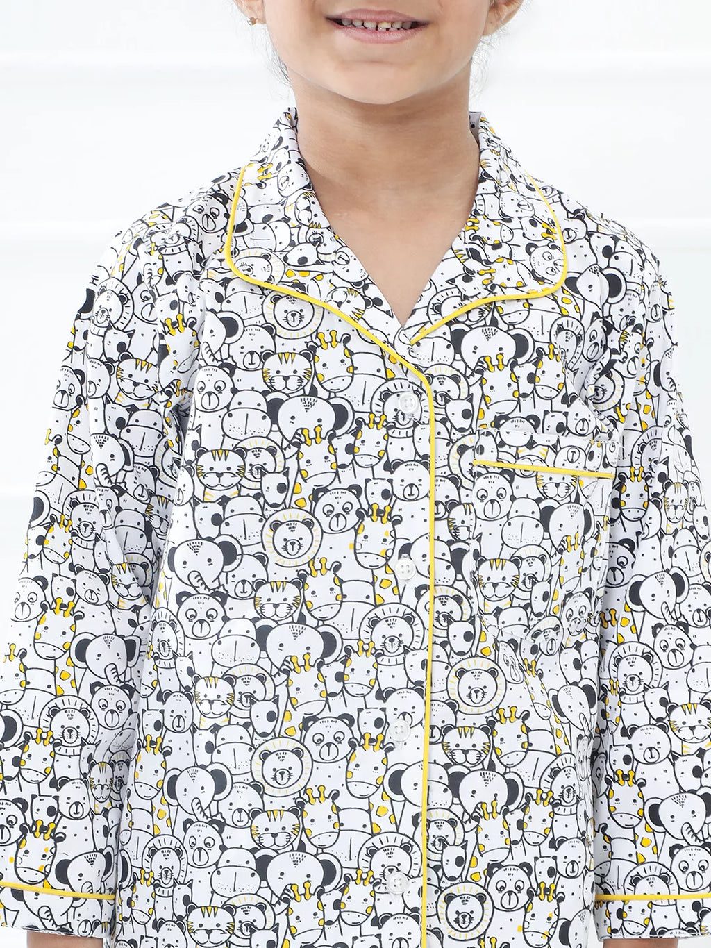 Child wearing a pajama set with bear pattern on a white background