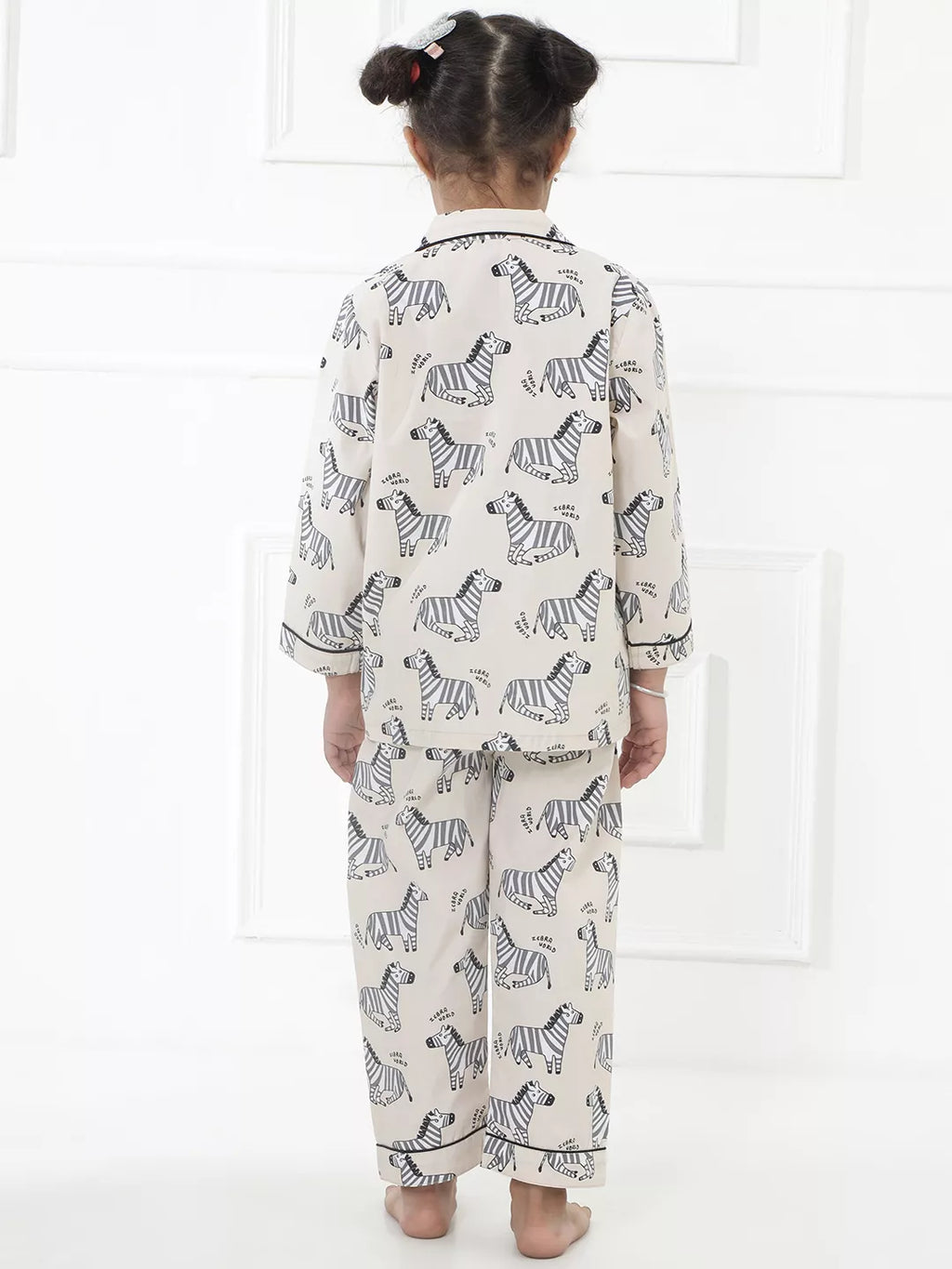 Child wearing zebra-patterned pajamas against a white background
