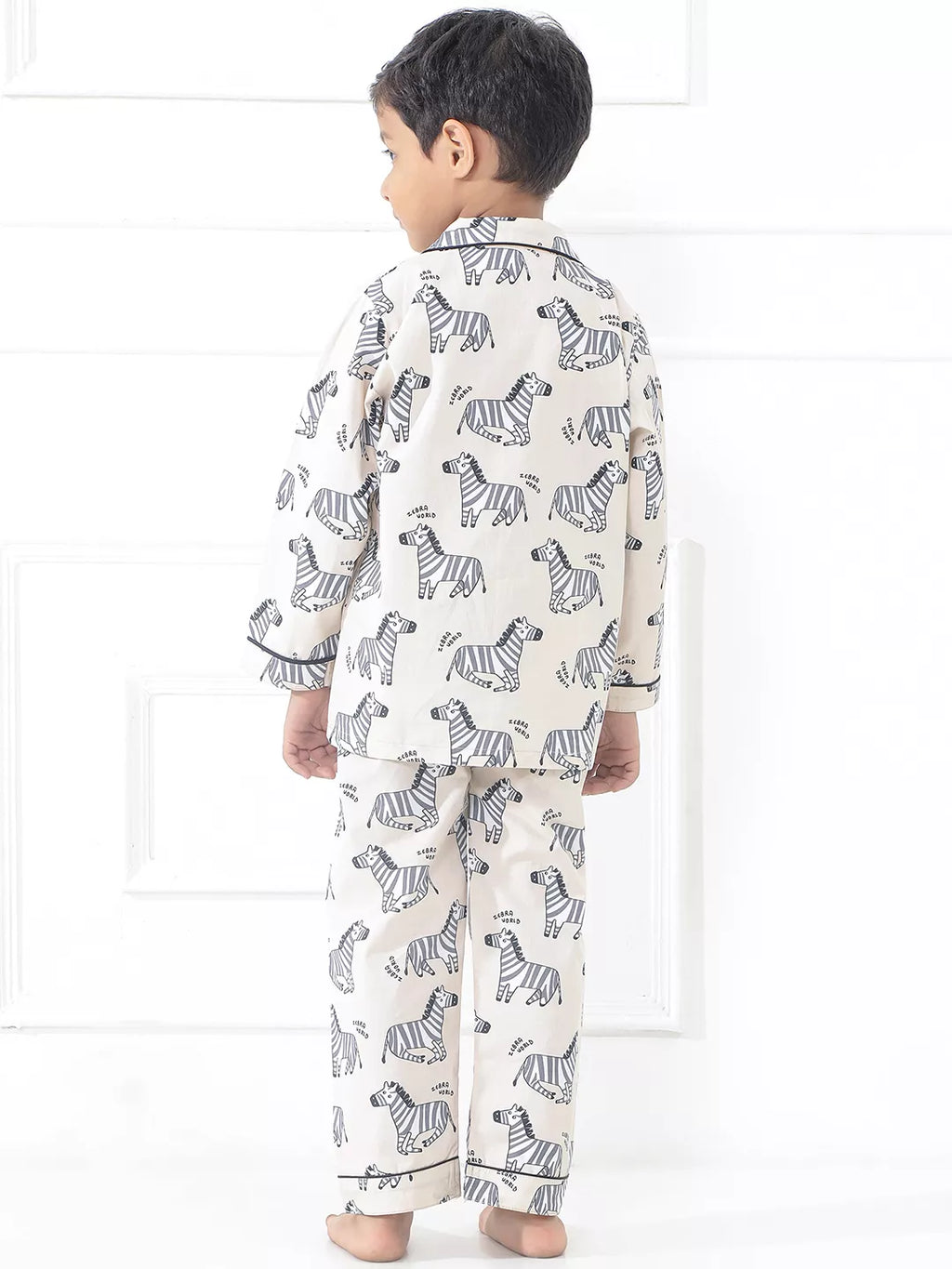Child wearing zebra-patterned pajamas on a white background