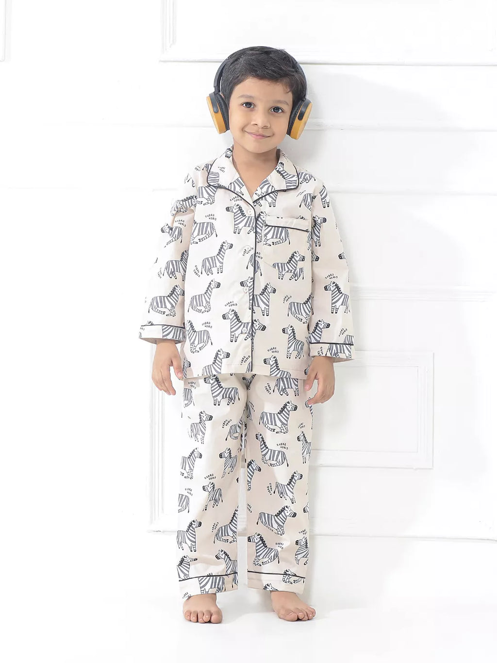 Child wearing zebra-patterned pajamas on a white background