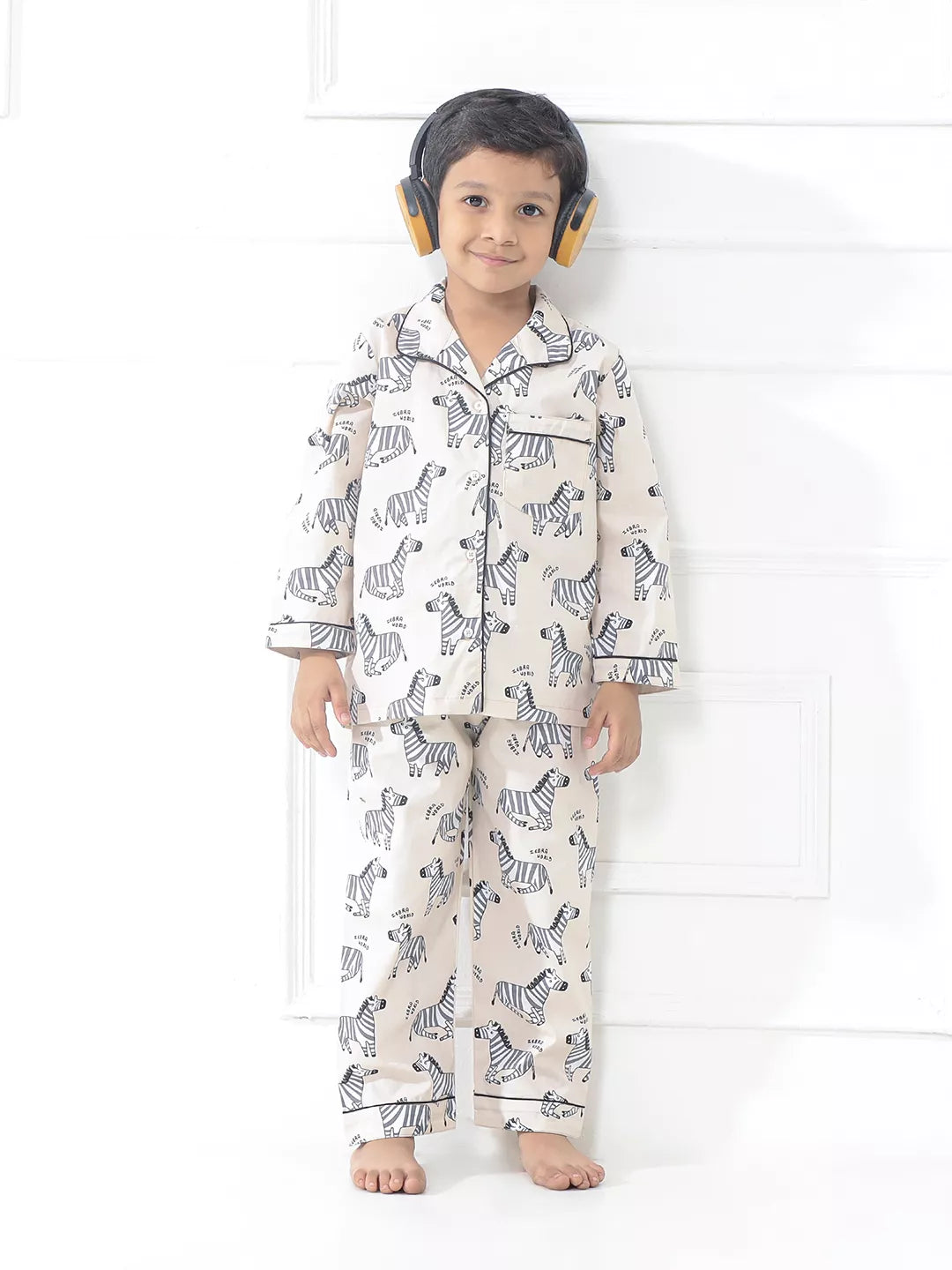 Child wearing zebra-patterned pajamas on a white background