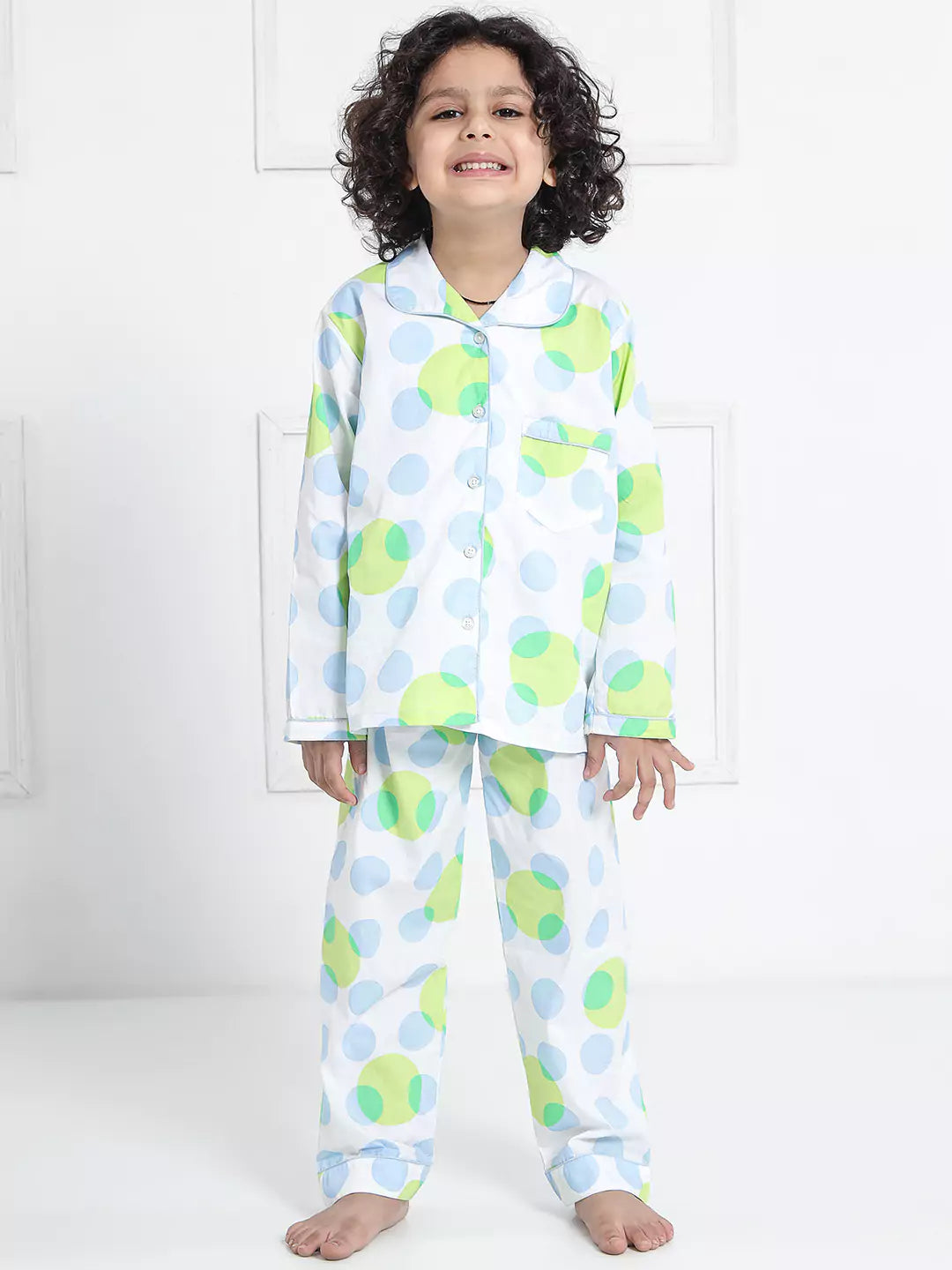 Child wearing a colorful polka dot pajama set against a white background