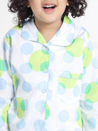 Boy wearing a colorful polka dot shirt with a white background