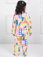 Child wearing a colorful geometric-patterned outfit on a white background